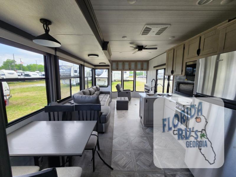 Forest River RV Salem Villa Series 40FDEN interior view for the living room and kitchen. Plenty of windows for natural lighting, a massive slide out, and plenty of seating.